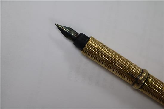 An Edwardian engine turned yellow metal fountain pen, with engraved inscription, 12.6cm.